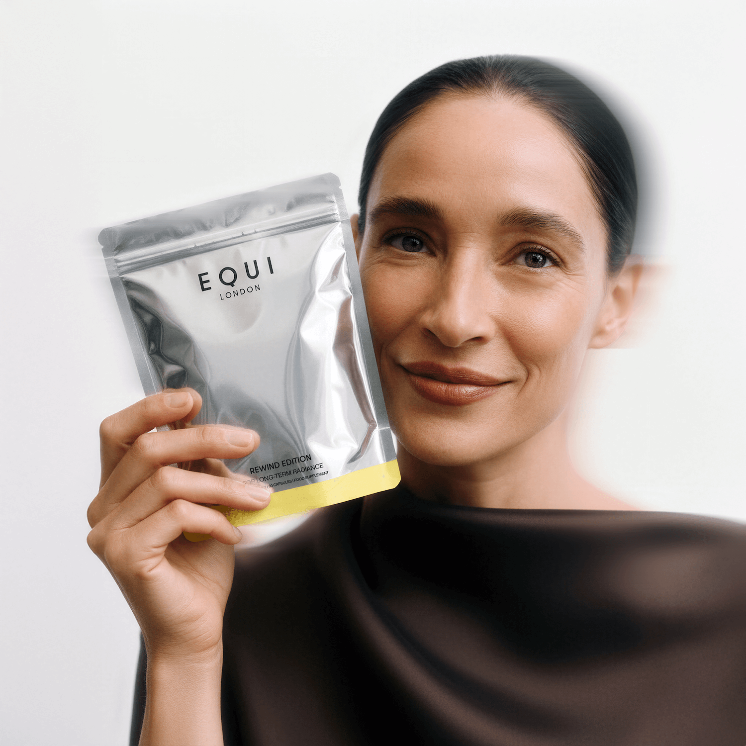 Woman holding an Equi London Rewind Edition against a white background